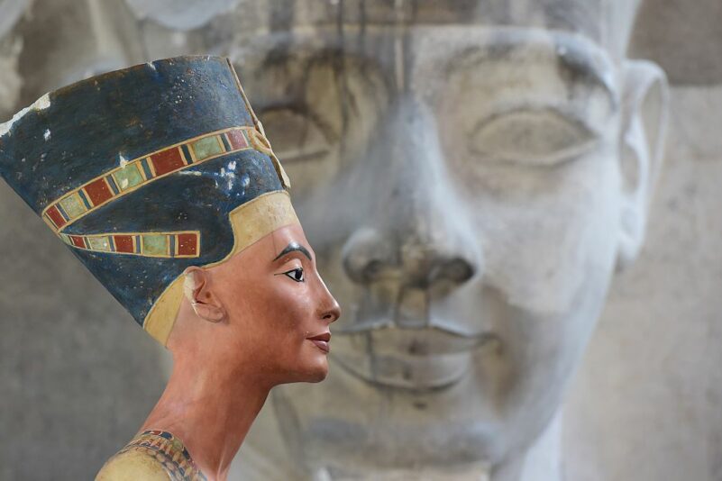 Kopie der Büste der Nofretete vor einer Sphinx