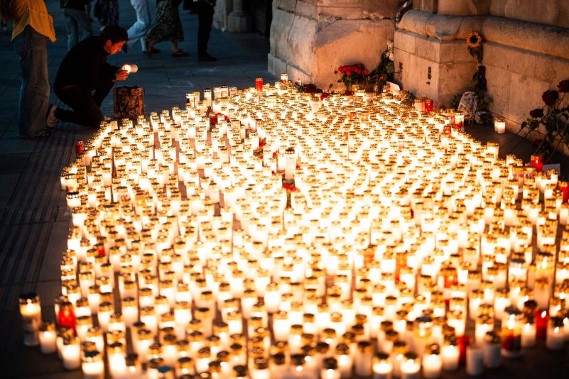 Menschen legen nach dem Amoklauf in einer Schule in Graz Kerzen vor dem Stephansdom nieder.
