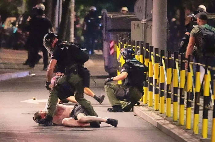 Polizisten in Schutzbekleidung nehmen einen Mann fest, nachdem sie Demonstranten am Ende einer Anti-Regierungs-Kundgebung angegriffen hatten, die auf eine vorgezogene Wahl drängten.