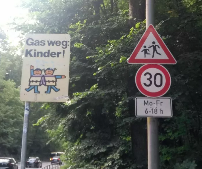 Achtung Kinder und Tempolimit-Schild mit einschränkenden Uhrzeiten