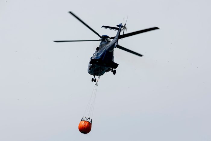 Ein Löschhubschrauber der Bundespolizei fliegt über dem Zeithainer Tagebau und nimmt Wasser auf, um den Waldbrand Gohrischheide zu bekämpfen.