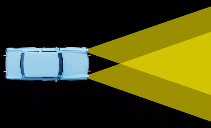 Scheinwerferlicht verdeutlicht die Teilcheneigenschaft von Licht. Wo sich die Lichtkegel überschneiden, wird es heller.