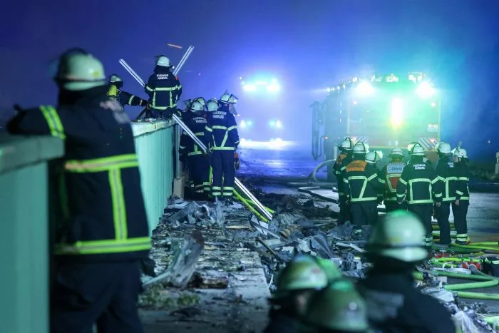 Einsatzkräfte der Feuerwehr sind dabei einen Brand in einem Industriegebiet im Hamburger Hafen zu löschen.