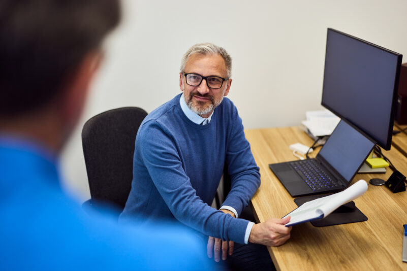 Business professionals having a focused discussion in an office space, showcasing collaboration. Foto: nortonrsx/iStock