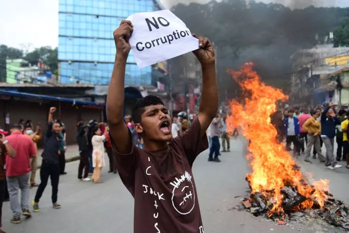 Ein Demonstrant in Nepal hält ein Blatt mit der Forderung nach einem Ende der Korruption hoch.
