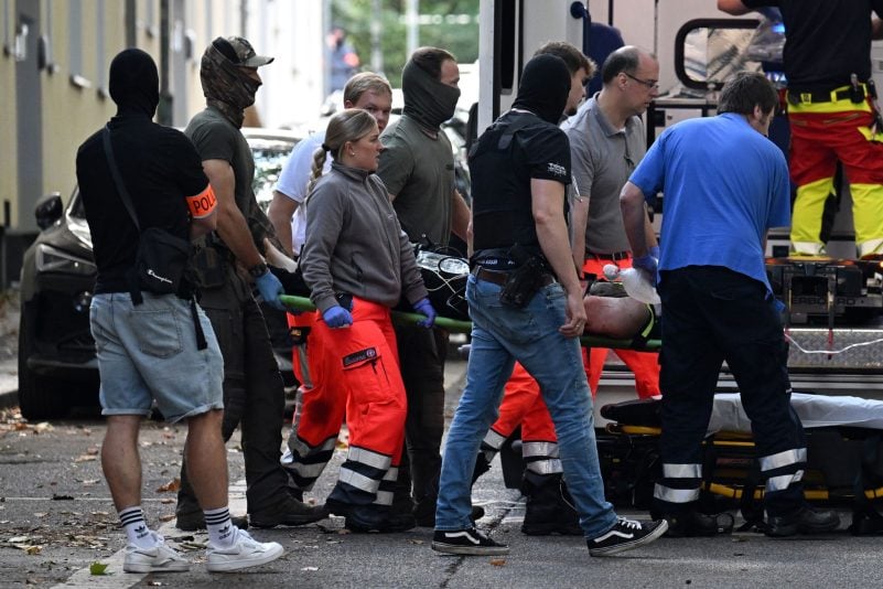 Der verletzte Tatverdächtige, der eine Lehrerin mit einem Messer angegriffen haben soll, wird zu einem Rettungswagen gebracht.