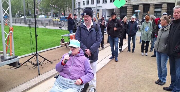 Eine Frau im Rollstuhl äußerte am 1. Oktober 2025 ihre Kritik am öffentlich-rechtlichen Rundfunk vor dem Bundesverwaltungsgericht in Leipzig. Foto: Bildschirmfoto/YouTube/Marcus Fuchs