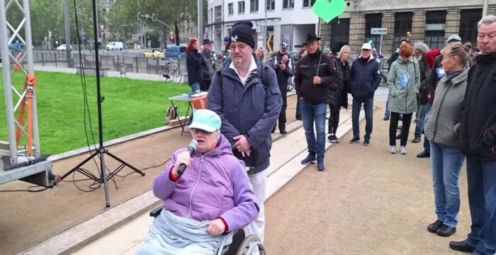 Eine Frau im Rollstuhl äußerte am 1. Oktober 2025 ihre Kritik am öffentlich-rechtlichen Rundfunk vor dem Bundesverwaltungsgericht in Leipzig. Foto: Bildschirmfoto/YouTube/Marcus Fuchs