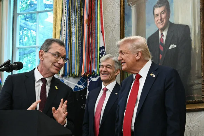 TOPSHOT - (L/R) Pfizer CEO Albert Bourla speaks as Medicare and Medicaid Administrator Mehmet Oz and US President Donald Trump look on during an announcement event on prescription drugs in the Oval Office of the White House in Washington, DC, on September 30, 2025. Trump on Tuesday announced a deal with the pharmaceutical giant Pfizer that he said would lower certain drug prices in the United States, without providing specifics. The US president, flanked by top officials, was scant on details but indicated the deal involves granting the company a three-year reprieve on planned pharmaceutical tariffs. The announcement saw Pfizer's stock price rise by five percent. (Photo by Brendan SMIALOWSKI / AFP) (Photo by BRENDAN SMIALOWSKI/AFP via Getty Images)