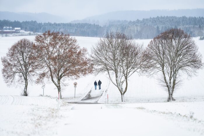 Winterwetter bei Bösingen: Fußgänger auf verschneitem Weg im Schwarzwald.