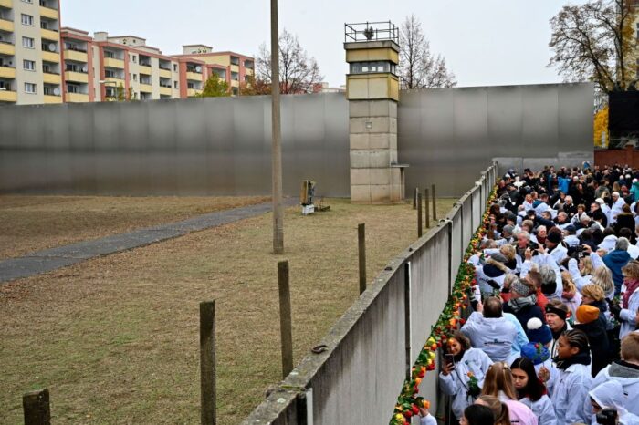 Blumen werden an der Gedenkmauer niedergelegt während der zentralen Gedenkzeremonie zum 30. Jahrestag des Mauerfalls am 9. November 2019 am Berliner Mauerdenkmal an der Bernauer Straße in Berlin. – Deutschland feiert 30 Jahre seit dem Fall der Berliner Mauer, der das Ende des Kommunismus und die nationale Wiedervereinigung einleitete, während das westliche Bündnis, das diese Errungenschaften sicherte, zunehmend infrage gestellt wird. Foto: TOBIAS SCHWARZ/AFP via Getty Images