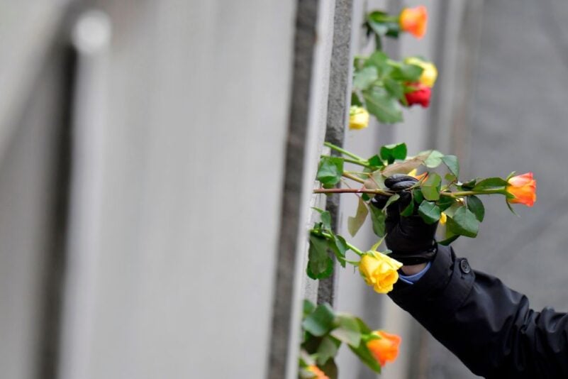 Blumen werden an der Gedenkmauer niedergelegt während der zentralen Gedenkzeremonie zum 30. Jahrestag des Mauerfalls am 9. November 2019 am Berliner Mauerdenkmal an der Bernauer Straße in Berlin. – Deutschland feiert 30 Jahre seit dem Fall der Berliner Mauer, der das Ende des Kommunismus und die nationale Wiedervereinigung einleitete, während das westliche Bündnis, das diese Errungenschaften sicherte, zunehmend infrage gestellt wird. Foto: TOBIAS SCHWARZ/AFP via Getty Images