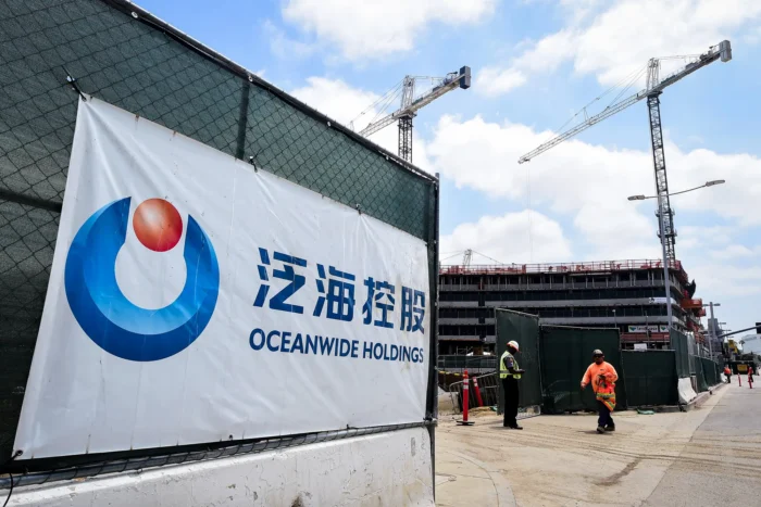 Ein Banner der chinesischen Oceanwide Real Estate Group ist am 17. Mai 2016 an ihrer Baustelle gegenüber dem Staples Center in Los Angeles zu sehen. Wohlhabende Chinesinnen und Chinesen bilden eine zentrale Kundengruppe für Geldwäschenetzwerke, die Gelder für US-Immobilienkäufe und Universitätsgebühren transferieren – und dabei Chinas strenge Devisen- und Kapitalverkehrskontrollen umgehen. Foto: Frederic J. Brown/AFP via Getty Images
