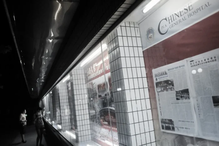 Menschen lesen Artikel und Fotos auf einem Anschlagbrett auf dem Gelände des 301-Krankenhauses in Peking, wo Spitzenpolitiker Chinas häufig medizinisch versorgt werden, am 6. Juli 2011. Goh Chai Hin/AFP via Getty Images